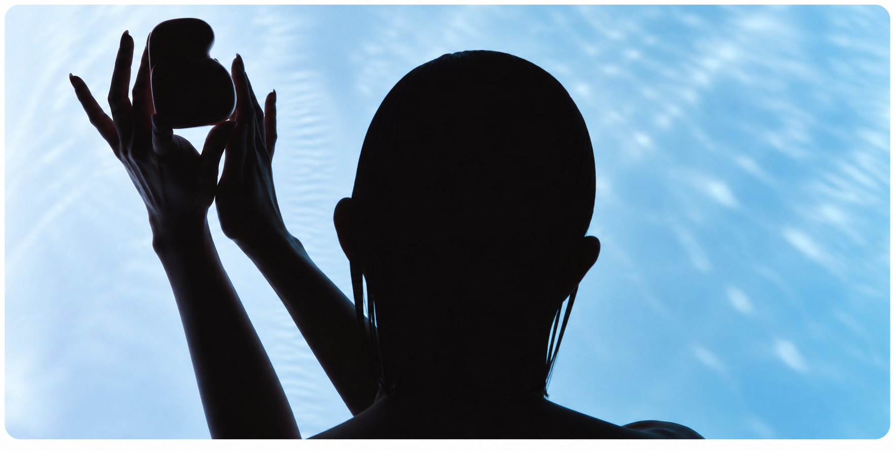 Silhouette presenting the Bewdy Guru Device against blue light
